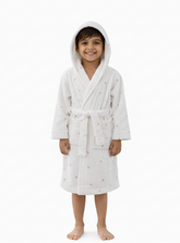 Child wearing a white hooded robe with small patterns on a white background