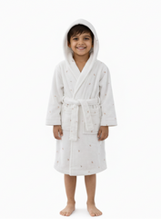Child wearing a white hooded robe with small patterns on a white background