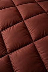 Close-up of a maroon quilt with a diamond pattern