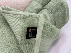 Green towel with a brand label on a white background