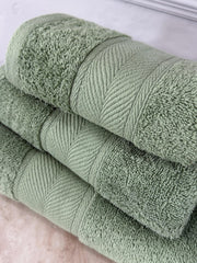 Stack of green towels on a white surface