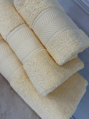 Stack of cream-colored towels on a light blue surface