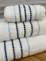 Three folded towels with blue and black stripes on a wooden surface.