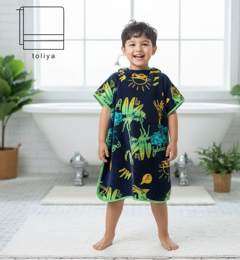 Child wearing a dark blue poncho with colorful dinosaur prints in a bright room.