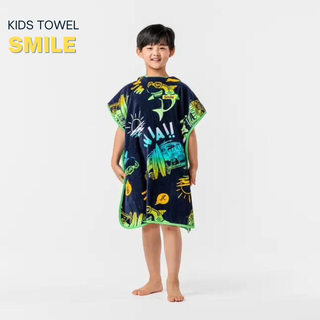 Child wearing a dark blue poncho with colorful dinosaur prints in a bright room.