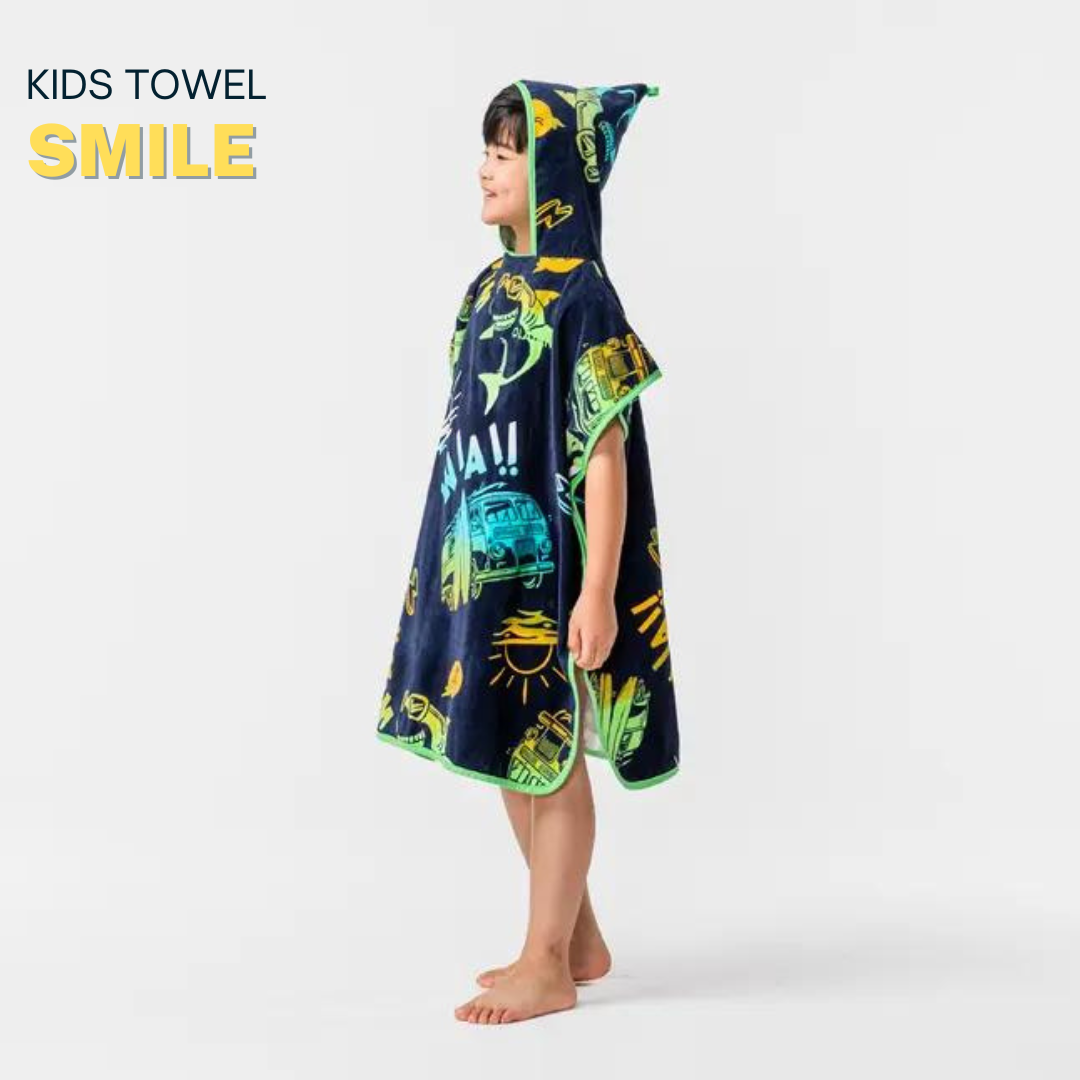 Child wearing a dark blue poncho with colorful dinosaur prints in a bright room.