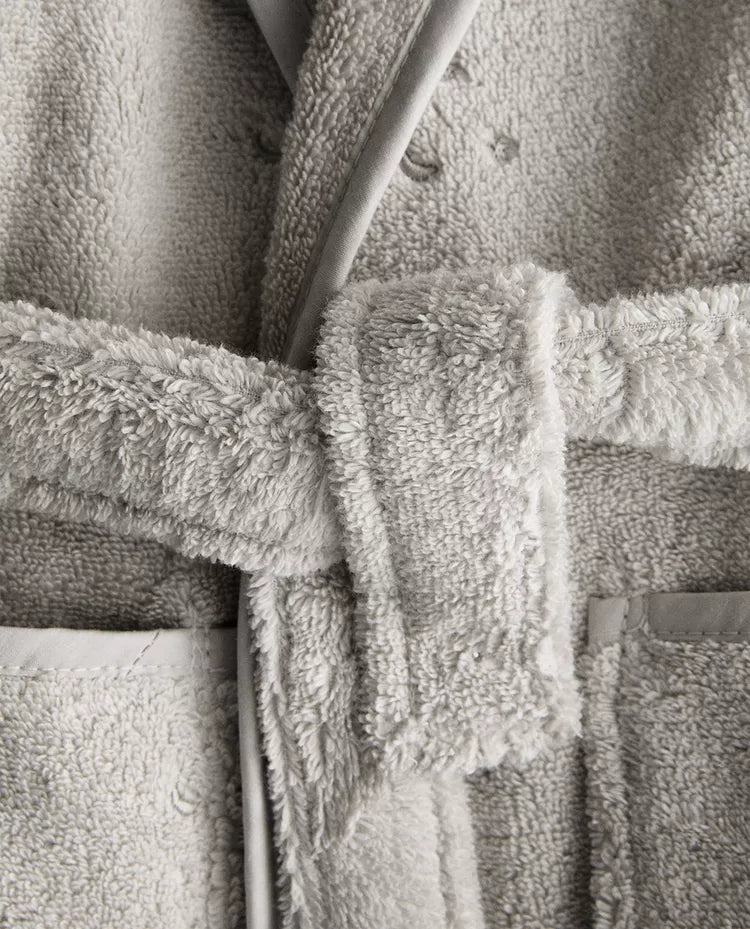 Child wearing a gray hooded robe on a white background