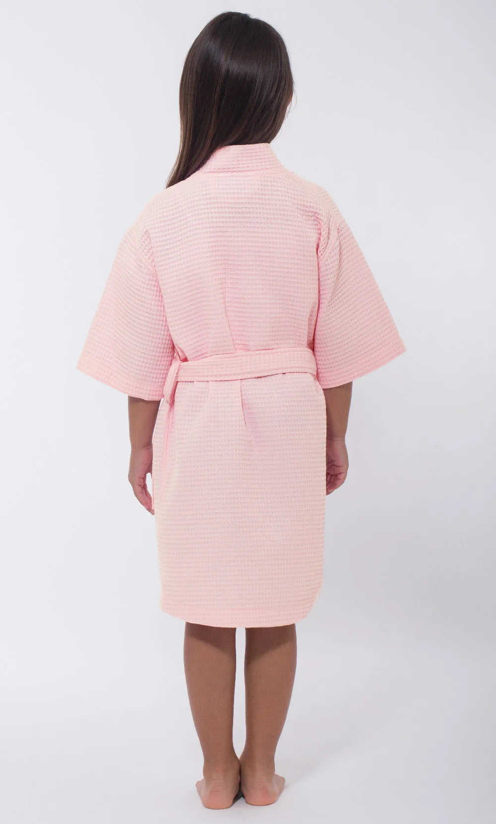 Child wearing a pink robe on a white background