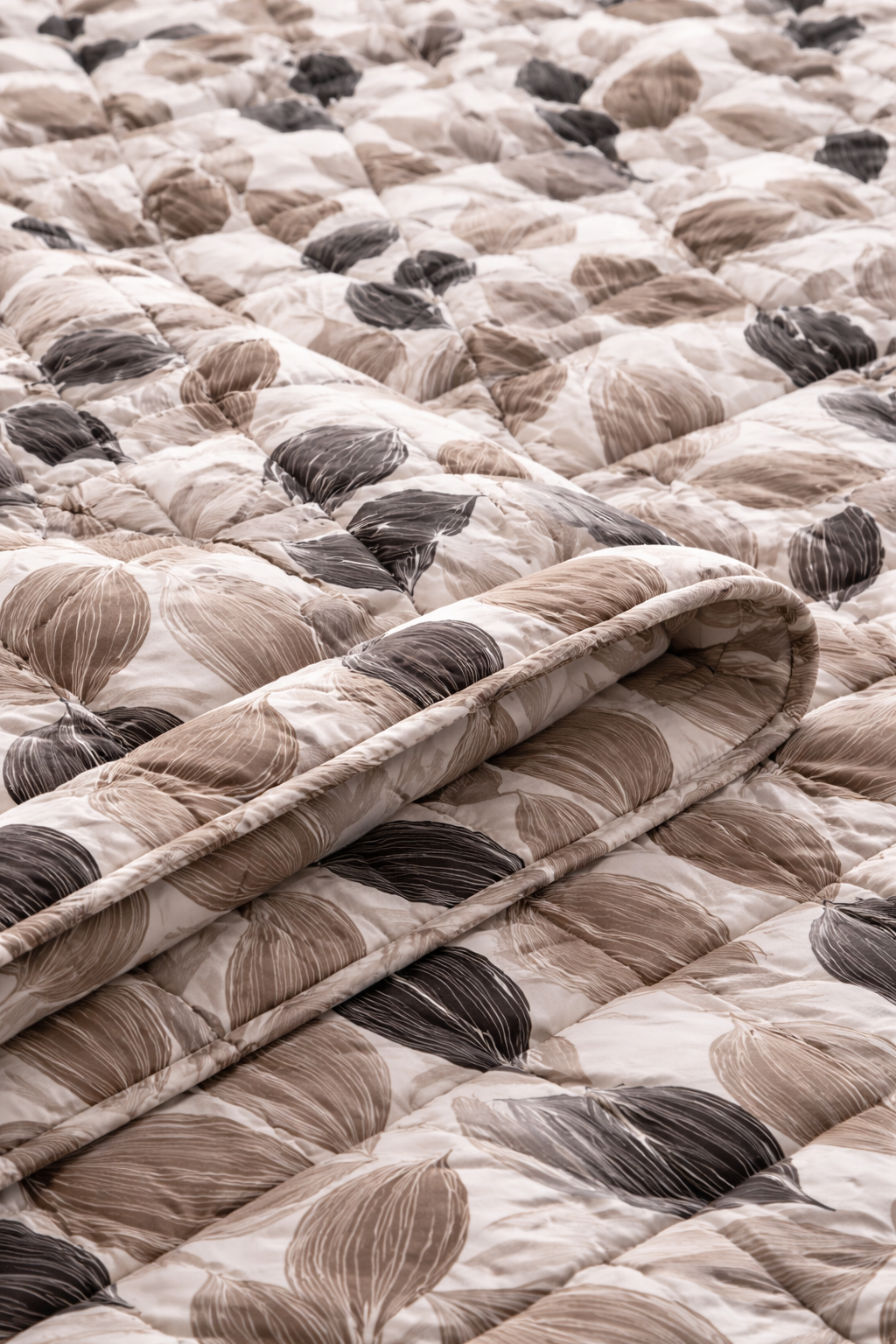 Close-up of a quilt with a leaf pattern in neutral colors