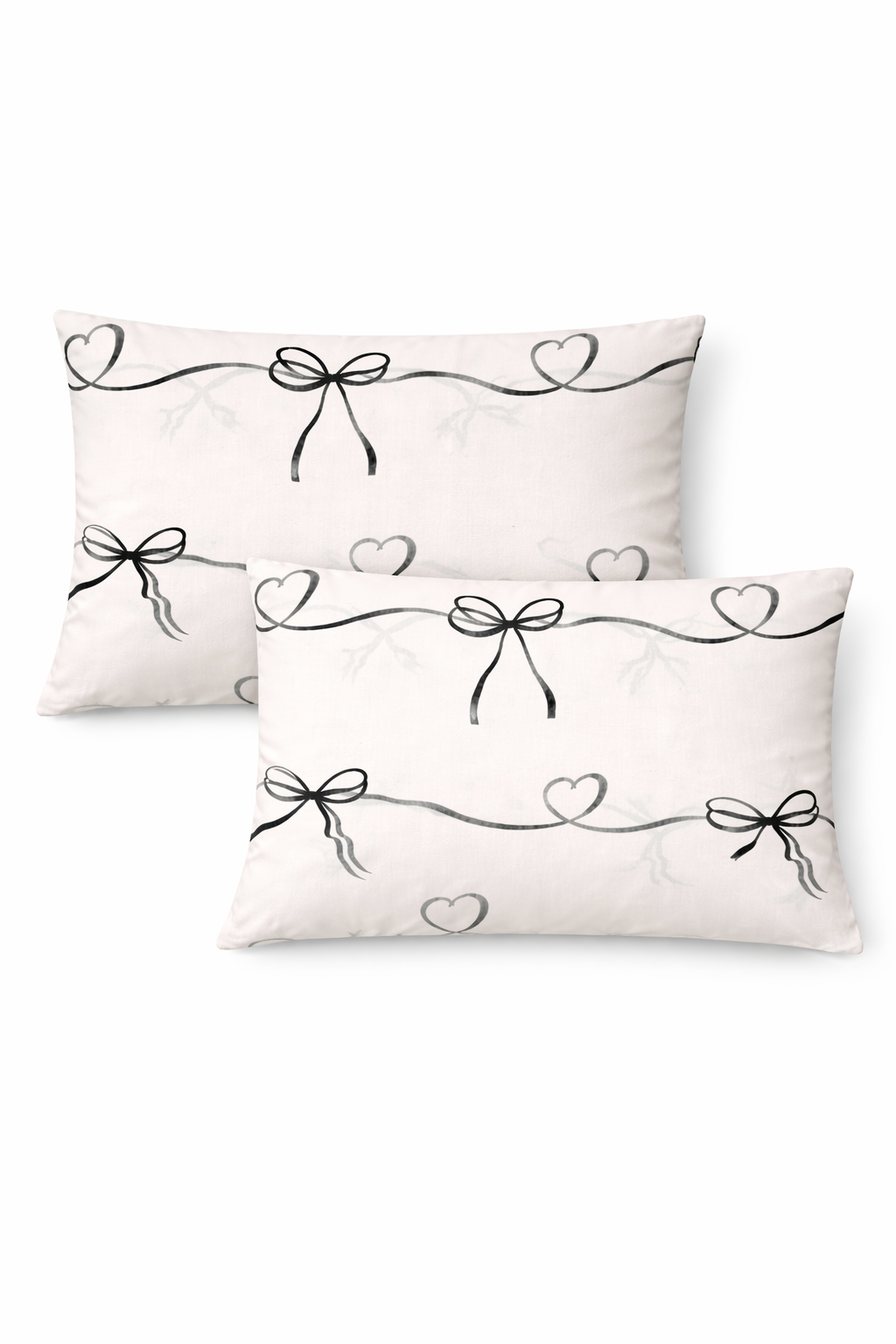 Two decorative pillows with black bow and heart designs on a white background
