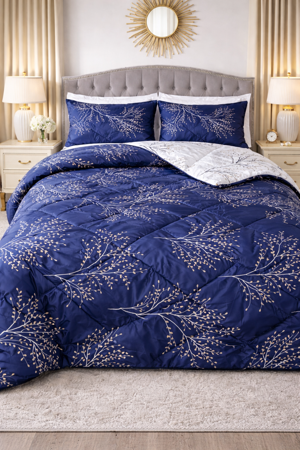 Blue floral patterned comforter on a bed in a bedroom setting with lamps and decor.