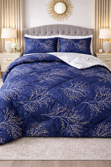 Blue floral patterned comforter on a bed in a bedroom setting with lamps and decor.
