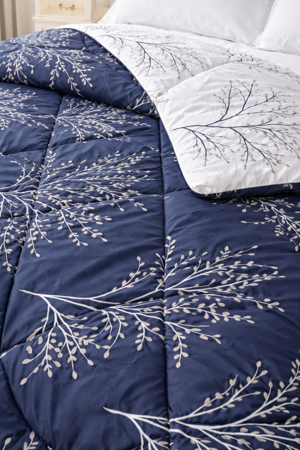 Navy blue and white floral patterned comforter on a bed