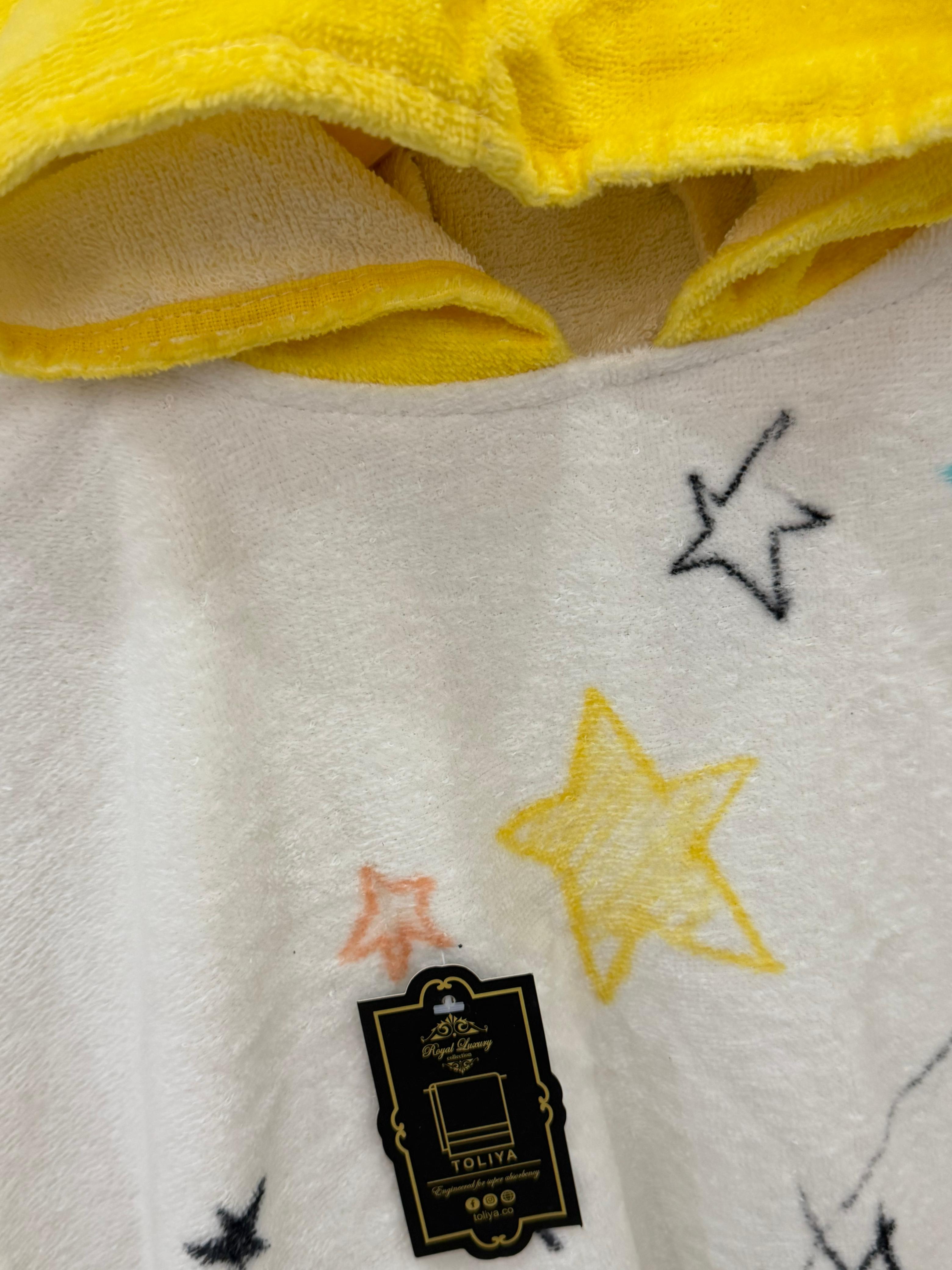 Close-up of a yellow and white blanket with star patterns and a brand tag.