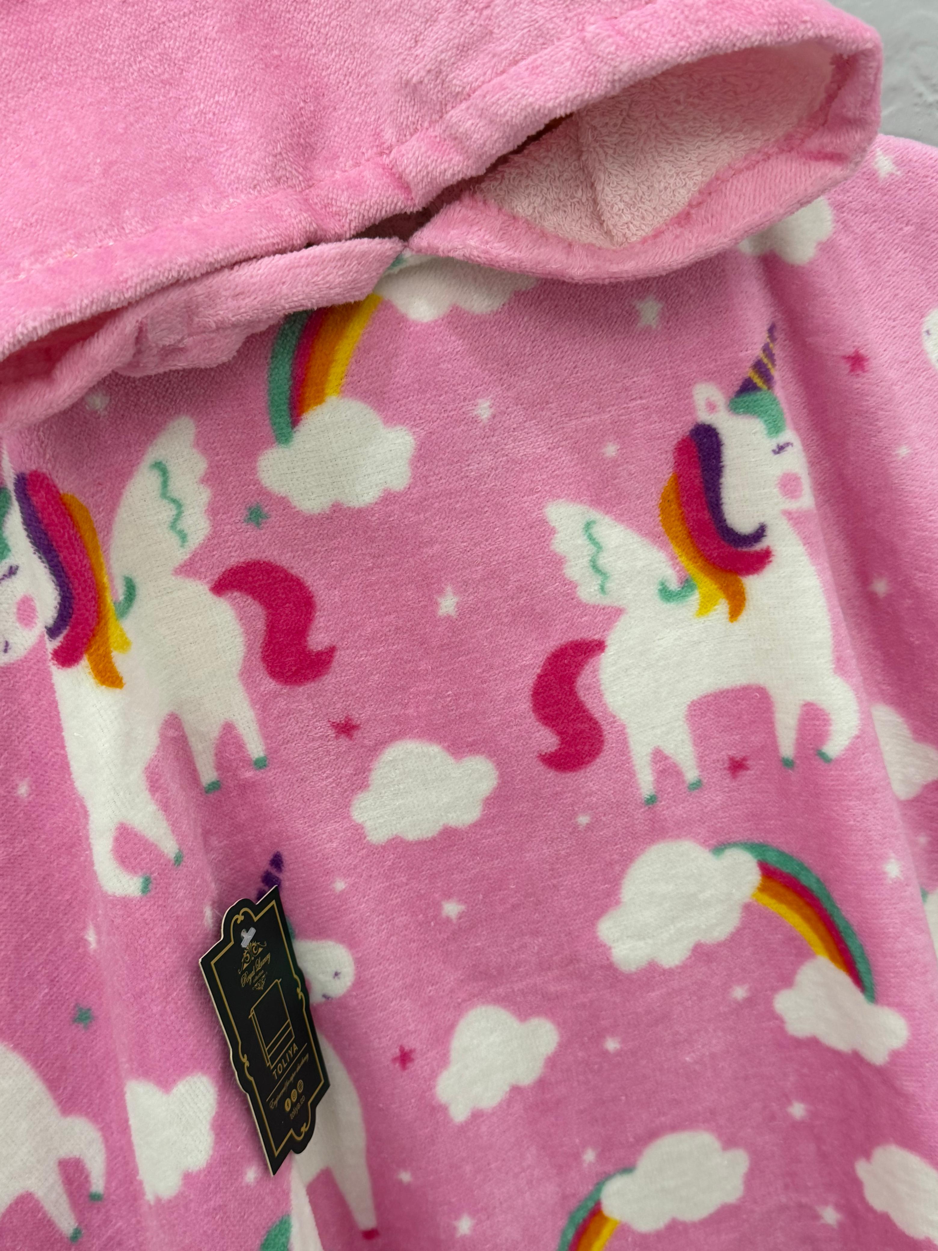 Pink fabric with unicorn and rainbow pattern, close-up view.