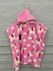 Pink poncho with unicorn pattern hanging against a gray wall