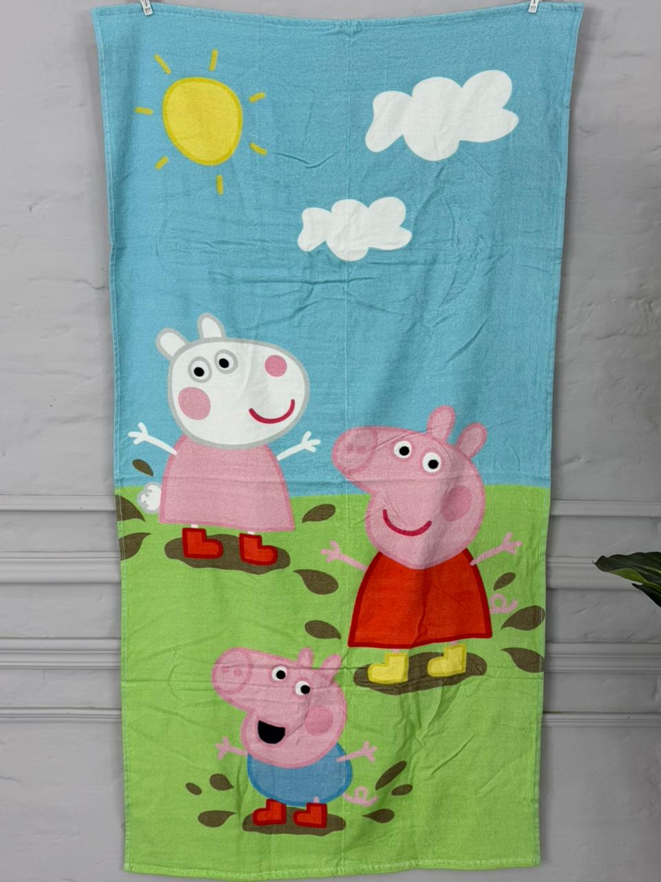 Children's towel with cartoon characters on a blue and green background