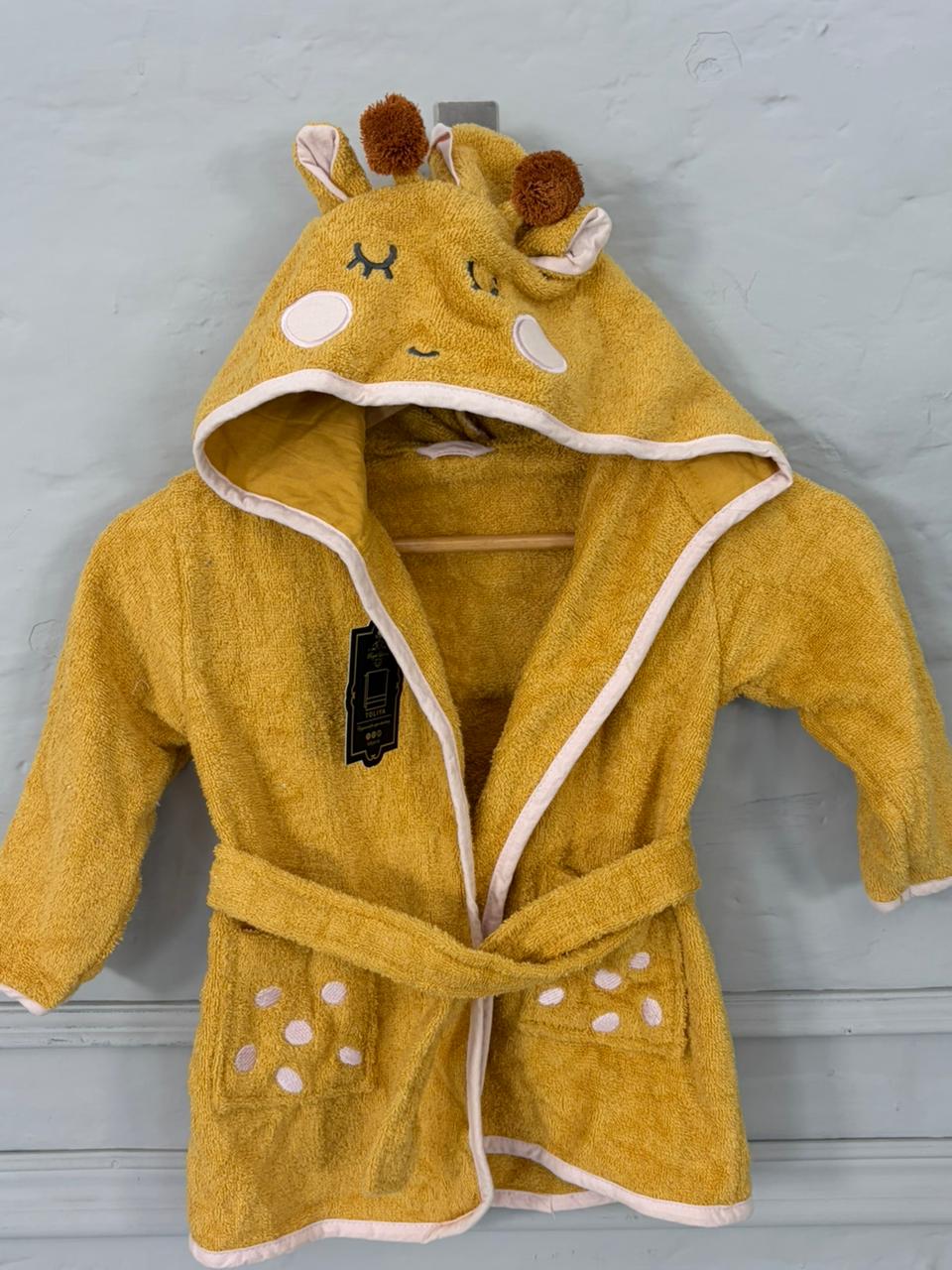 Yellow children's robe with animal design on a gray background