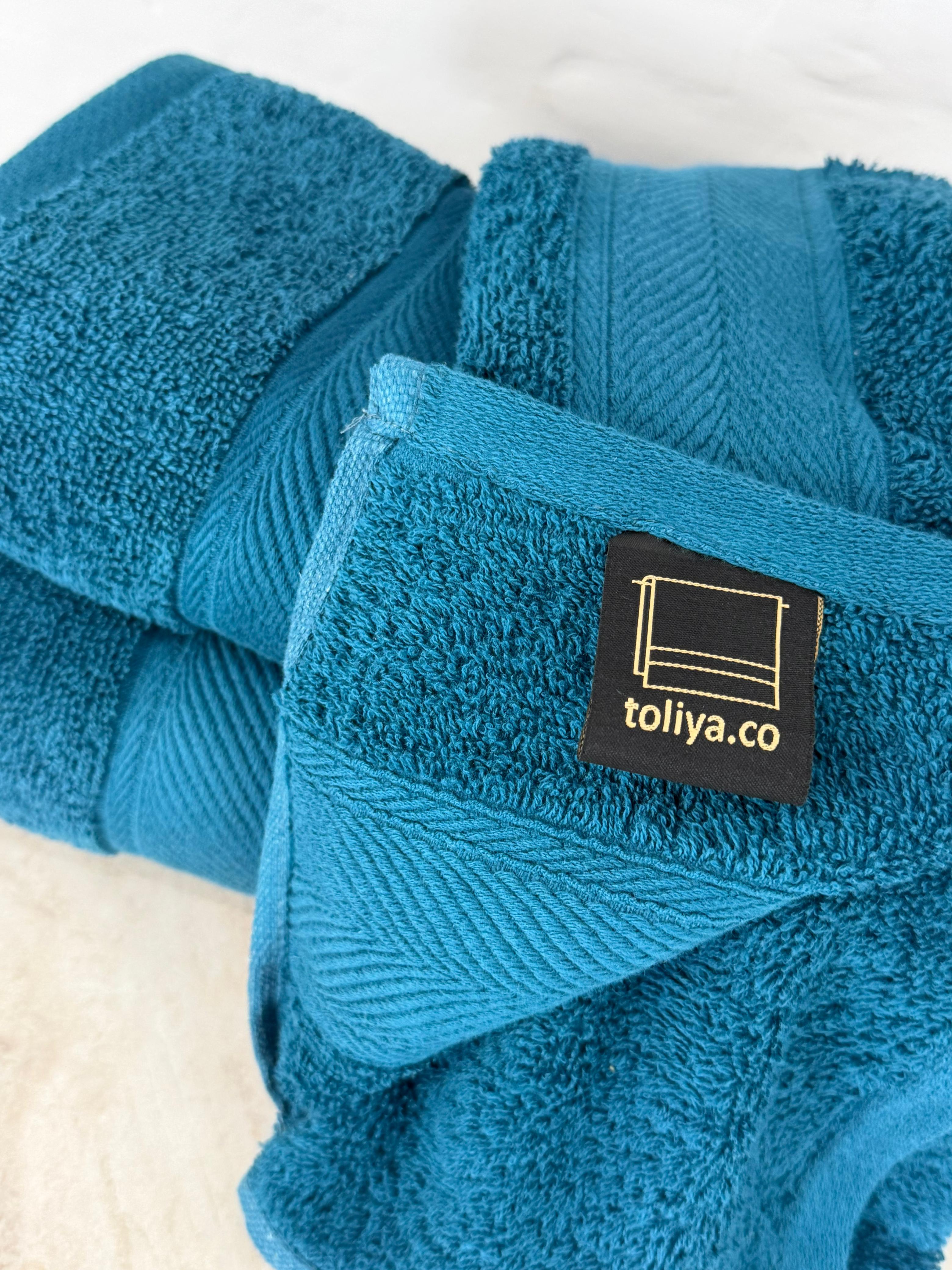 Blue towels with a 'toliya.co' label on a white background