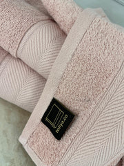 Close-up of a pink towel with a visible brand label on a light background