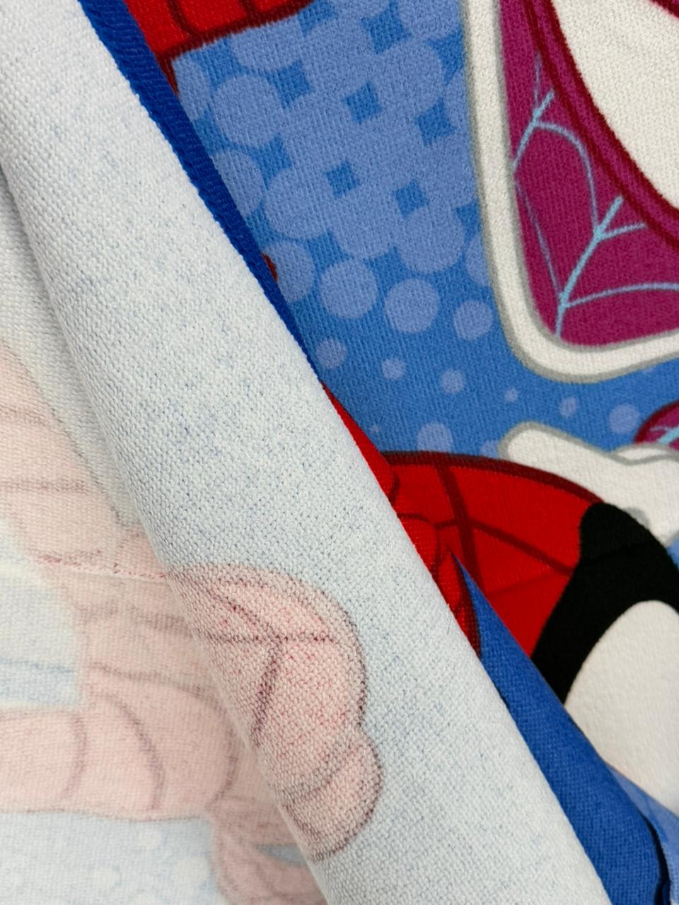 Close-up of a fabric with superhero design, featuring red, blue, and white colors.