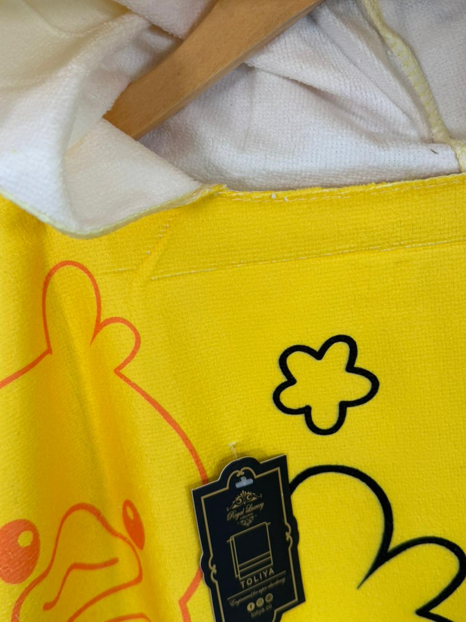 Yellow apron with cartoon designs and a brand tag on a white background