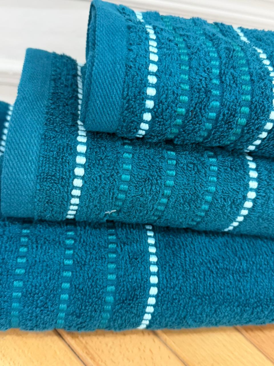 Set of blue towels with white stripes on a wooden surface